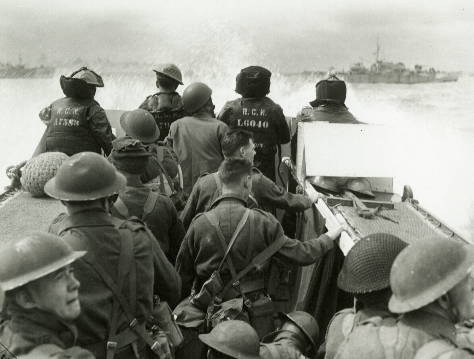 Original photograph courtesy of the Canadian War Museum titled "Infantrymen in a Landing Craft Assault (LCA) going ashore from H.M.C.S. PRINCE HENRY off the Normandy beachhead, France, 6 June 1944". This image depicts Canadian soldiers and sailors about seven miles from the beaches of Normandy. This moment embodies the bravery of the thousands who risked everything.